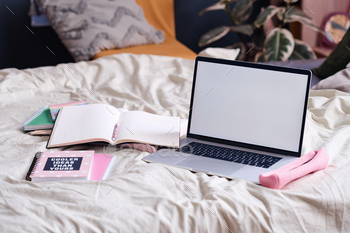 Laptop And Notebooks On Bed