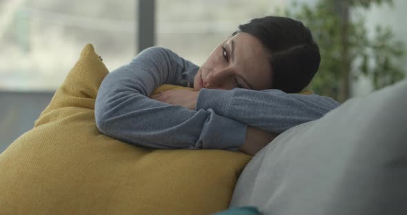Depressed woman hugging a cushion