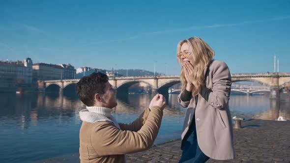 Handsome Young Man Proposing to His Girlfriend on Pier