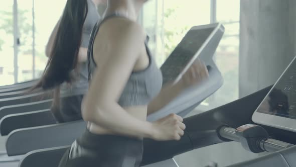 Asian young man and woman doing cardio exercise training with running on treadmill in sport gym.