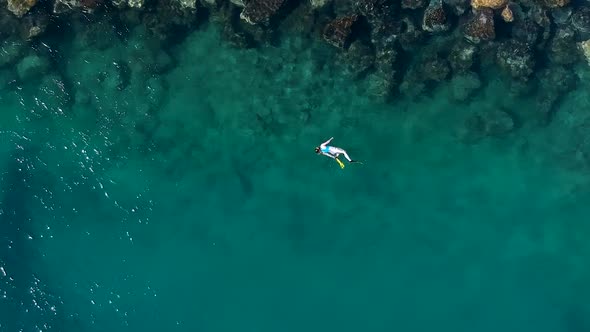 An aerial view of one person swimming above the water