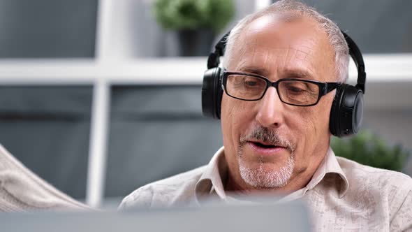 70s Grandfather in Headphones Communicating Online Video Call