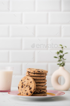 Cookies are spread out on a plate, a glass of fresh milk. Homemade cookies with chocolate chips.