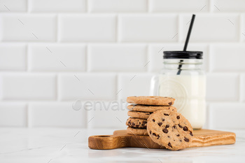 Cookies are spread out on a plate, a glass of fresh milk. Homemade cookies with chocolate chips.