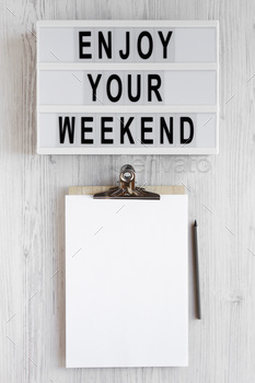 'Enjoy your weekend' words on a lightbox, clipboard with blank sheet of paper