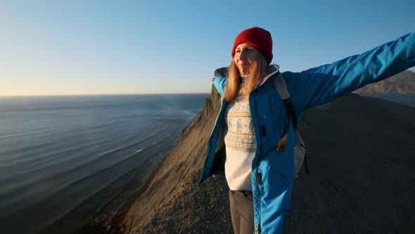 Young Attractive Girl Hiker Goes Along the Sandy Ledges or Seaside Cliff