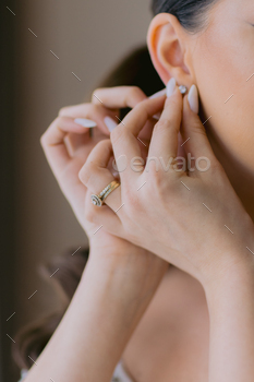 Close-up of a woman fixing her earring.
