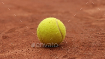 a tennis ball sits on a tennis court, ready to serve the ball