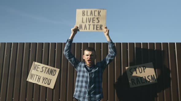 Man waving "black lives matter" sign during rally about the plurality of violence & police brutality