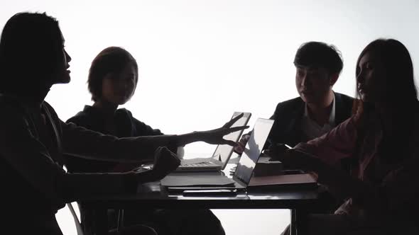 A team of young businessmen and businesswomen working and communicating together in an office