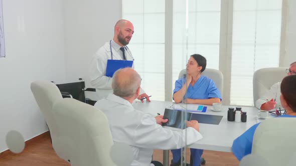 Medical Practitioner Presenting Diagnosis to Colleagues