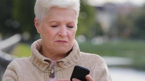 Unhappy Displeased Retired Lady Irritated By Bad Smartphone Work Outdoor