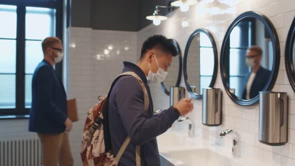 Students in Mask Visiting Restroom in College and Washing Hands with Soap