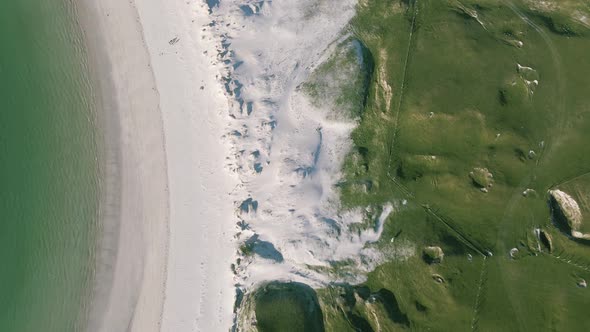 White Sand With The Lush Green Grassland By The Dog's Bay Beach In Roundstone, Connemara, Ireland On