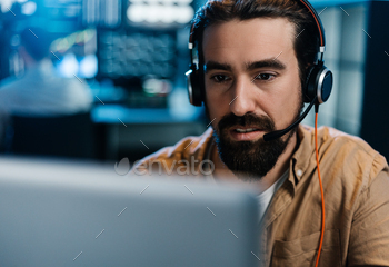 Young stock exchange trader working in dark office