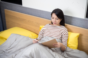 Woman read the notebook on bed