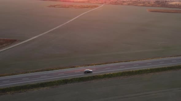 Aerial View of Intercity Road with Fast Driving Cars at Sunset