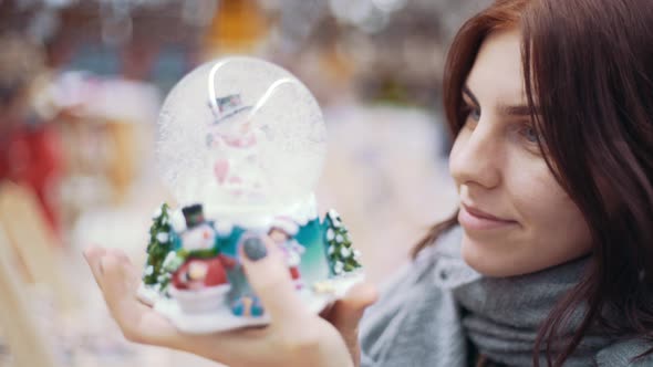 A Young Beautiful Woman Walks Around the Store and Selects Christmas Decorations and Decorations to