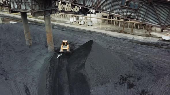Coal handling operations at the factory. Crawler bulldozer works. Aerial view.