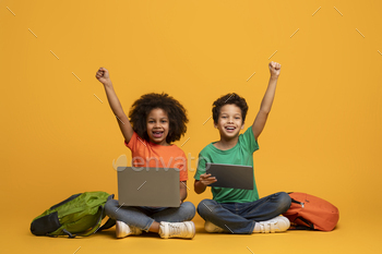 Two Children Sitting on the Floor With Devices