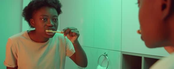 African American Woman Brushing Teeth at Home