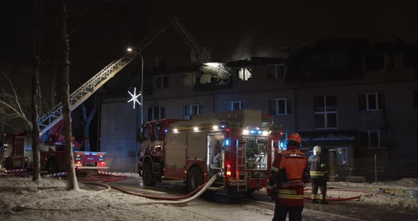 Firefighters Put Out Fire in Burning Apartment House at Night