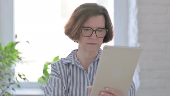 Portrait of Senior Woman Having Loss on Tablet in Office