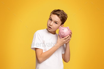 Young Boy Holding Pink Piggy Bank