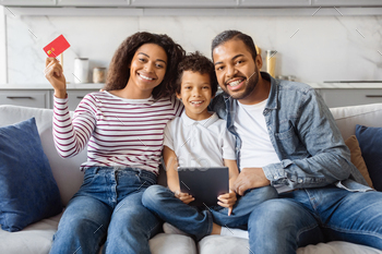 Smiling Family Holding Credit Card and Tablet