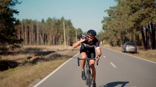 Cyclist Riding On Carbon Bike In Lycra Sportswear. Muscular Fitness Biker Cycling Workout.