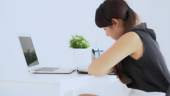 Young asian woman sitting in the living room study and learning writing notebook and diary.