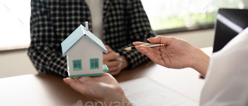 Real estate agent talking about the terms of the home purchase agreement and the customer to