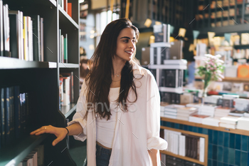 Smiling ethnic woman standing in library