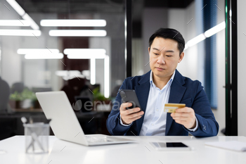 Businessman making payment with credit card and smartphone