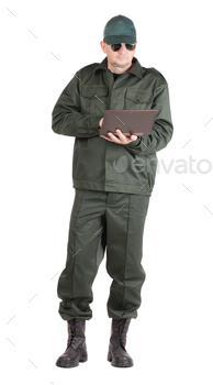 Man in workwear stands with notebook