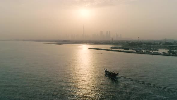 Aerial view of boat moving toward Dubai during a dusty day, Dubai, U.A.E.
