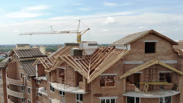 Aerial Construction of a Brick House. Installation of Wooden Roof