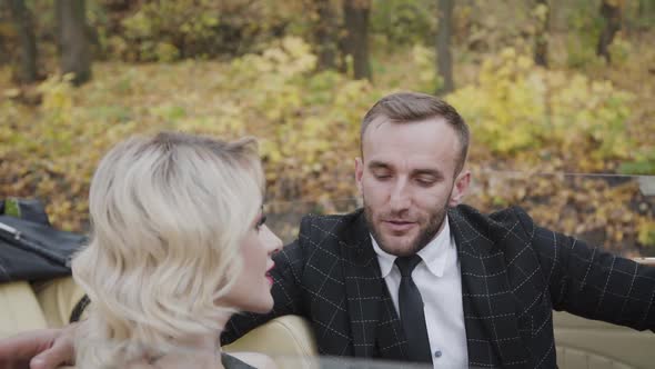 Handsome Gentleman Talking with Attractive Blonde in Retro Cabriolet