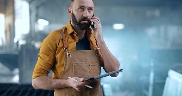 Factory Worker with Tablet and Phone at the Manufacturing