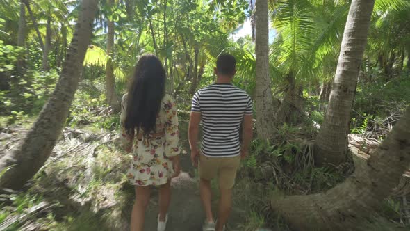 A man and woman couple walking on a path in the tropical islands in French Polynesia