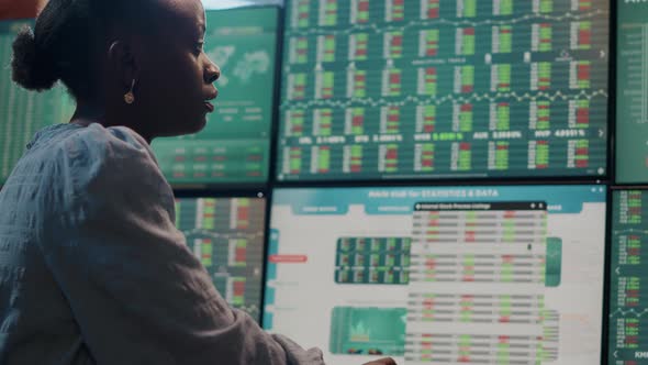 Female Broker Looking at Multi Monitors with Forex Exchange Statistics