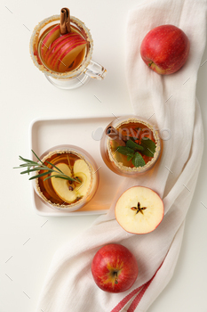 Glasses with apple cider and red apples on white background, top view