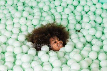 Cheerful child in ball pit