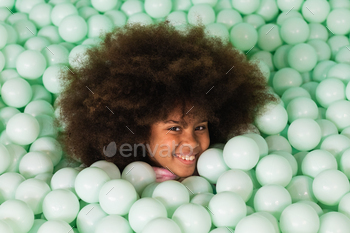 Cheerful child in ball pit
