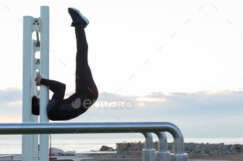 Sportsman performing exercise on crossbar