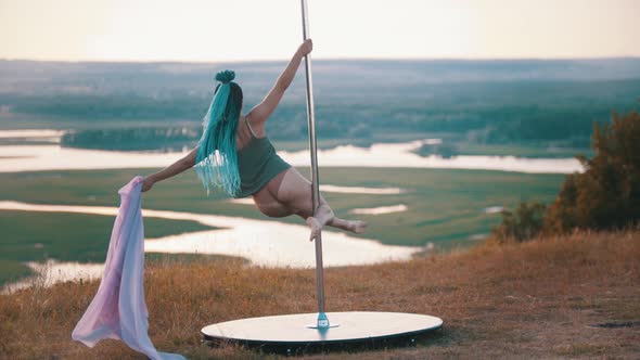 Woman with Blue Braids Spinning on the Pole with Pink Veil