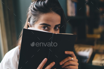 Serious woman with book looking at camera