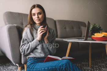 Woman sitting on floor and reading book