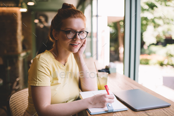 Smiling woman with notebook and laptop