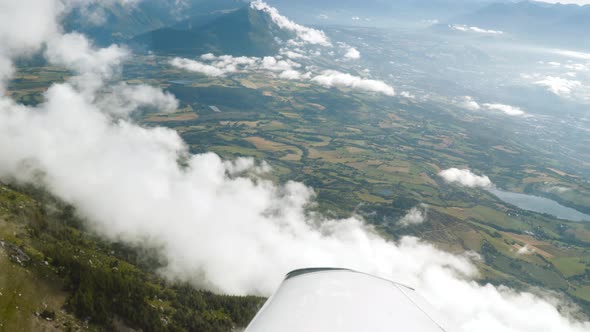 Flying above clouds, lake. Wing of private aeroplane, Alpine nature, mountains, Flight cabin view